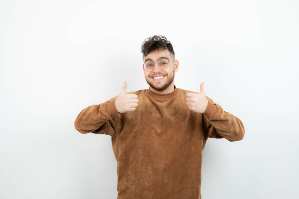Photo of young handsome man standing and giving thumbs up. High quality photo - Photo, Image