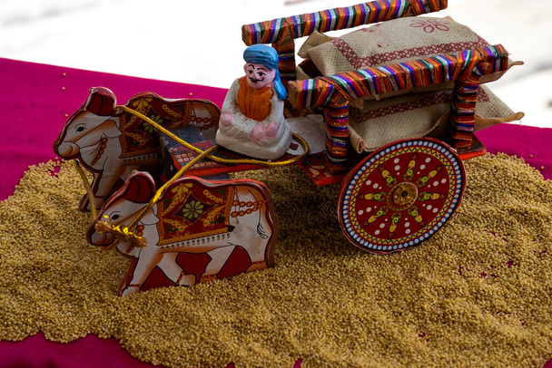 Фотографія чудового індійського дерев'яного візка та статуї фермера, що сидить на возі, трималась на зернах у сонячний день у місті Карнатака, Індія. невиразний фон. - Фото, зображення