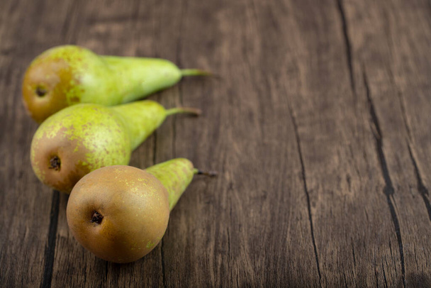 Three ripe delicious green pears on wooden background. High quality photo - Zdjęcie, obraz