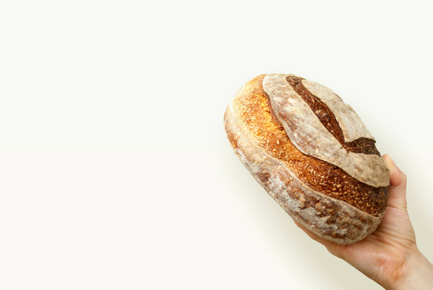 Hand holding bread on white background - Фото, зображення