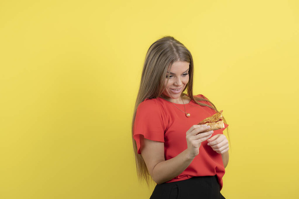 Εικόνα σαγηνευτικής γυναίκας που κρατάει ένα κομμάτι νόστιμης πίτσας. Υψηλής ποιότητας φωτογραφία - Φωτογραφία, εικόνα