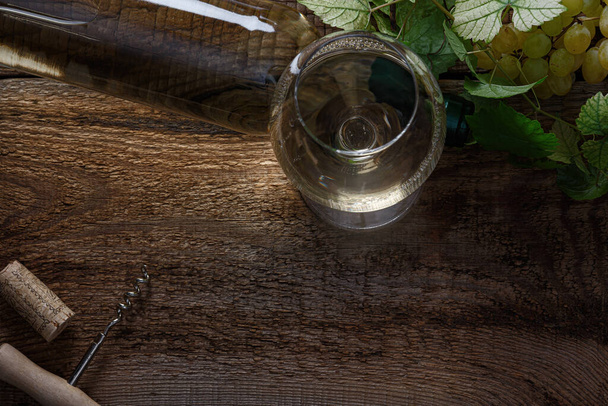 Ein Glas Weißwein auf einem Holztisch. Ansicht von oben. - Foto, Bild