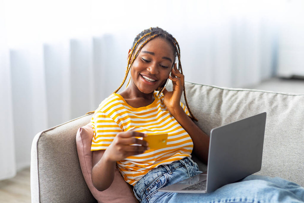 Cheerful black woman shopping online, having phone conversation - Photo, Image