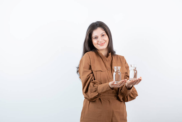 Image of smiling woman holding two glasses of water. High quality photo - Foto, afbeelding