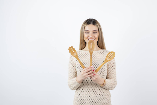 Foto di attraente giovane donna in piedi e in possesso di utensili da cucina. Foto di alta qualità - Foto, immagini