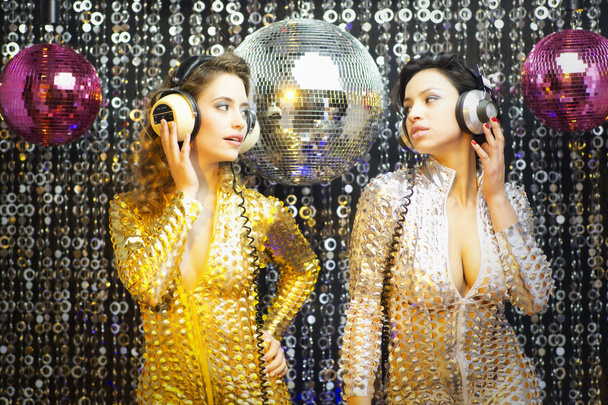 two beautiful sexy disco women in gold and silver catsuits danci - Photo, Image