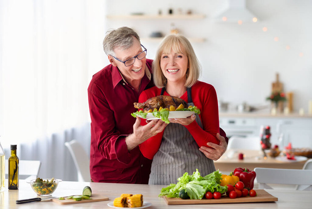 Casal sênior caucasiano positivo cozinhar Ação de Graças ou peru de Natal juntos na cozinha - Foto, Imagem