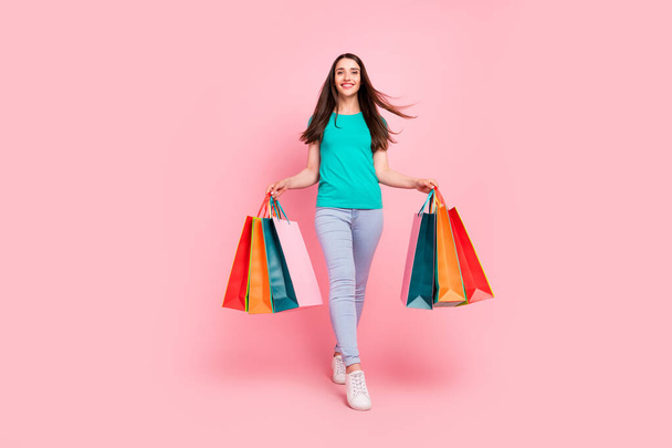 Full body photo of young woman happy positive smile go walk black friday shopaholic isolated over pastel color background - Photo, Image