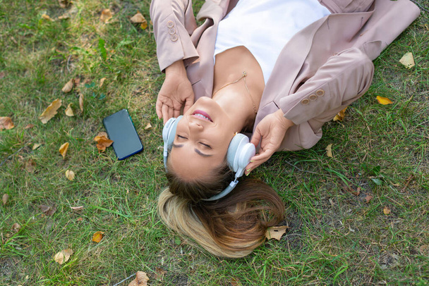 Close-up foto - donna nell'erba godendo la musica. - Foto, immagini