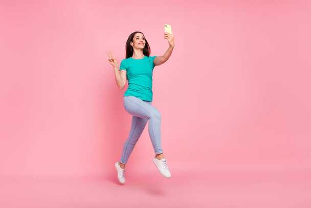 Täysikokoinen profiili sivukuva nuori nainen onnellinen hymy hypätä tehdä selfie matkapuhelin näyttää v-merkki eristetty pastelli väri tausta - Valokuva, kuva