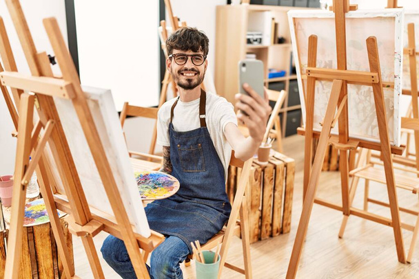 Jeune artiste hispanique homme faisant selfie par le smartphone dessin au studio d'art. - Photo, image