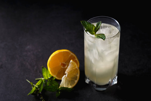 Refreshing summer non-alcoholic lemonade with ice, fresh mint and lemon. Top view, place for text. Fruit background with copy space. Still life food. - Foto, Imagem