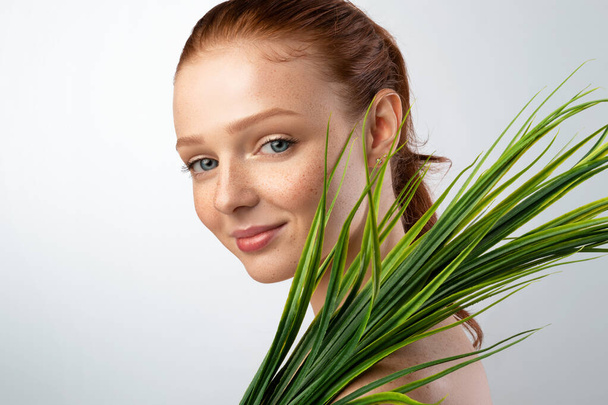 Pretty Young Lady Holding Green Plant Standing Over Gray Background - Photo, image