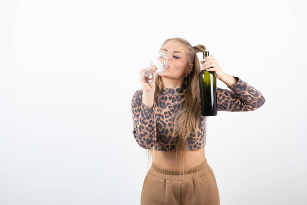 Photo of young attractive woman model holding wine bottle and glass . High quality photo - Foto, imagen