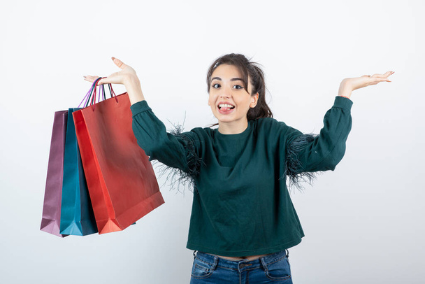 Retrato de una mujer joven sosteniendo una gran cantidad de bolsas de compras de colores. Foto de alta calidad - Foto, imagen