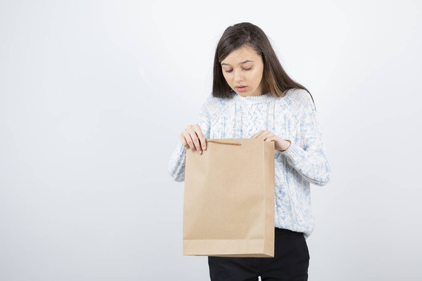 Portré tini lány pulóverben kezében bevásárló táskák - Fotó, kép