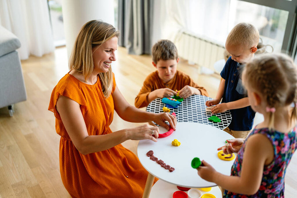 Mother teaches preschooler kids to do craft items. Family, children, education, happiness concept. - Fotó, kép