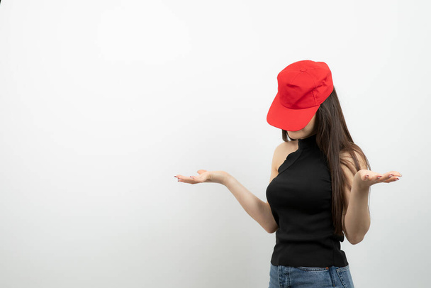 Portrait de jeune femme en bonnet rouge debout sur blanc. Photo de haute qualité - Photo, image