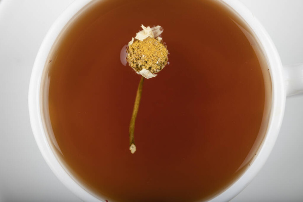 Filiżankę herbaty z suszonymi kwiatami umieszczonymi na kamiennym stole. Wysokiej jakości zdjęcie - Zdjęcie, obraz