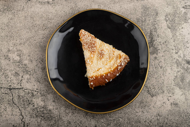 Fatias de bolo de sobremesa com raspas de coco colocadas em uma mesa de pedra. Foto de alta qualidade - Foto, Imagem