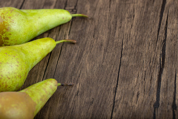 Three ripe delicious green pears on wooden background. High quality photo - Photo, Image