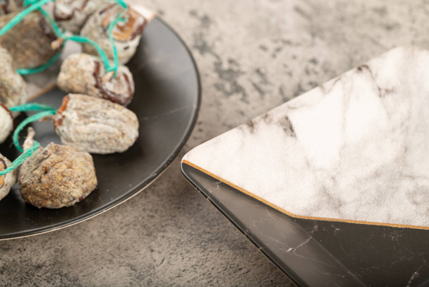 Teller mit köstlichen getrockneten Kaki-Früchten auf Steinhintergrund. Hochwertiges Foto - Foto, Bild