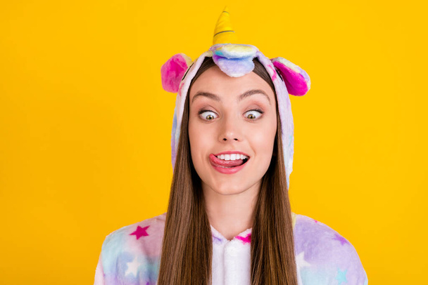 Photo portrait female teenager funny pajama showing tongue fooling grimacing isolated vibrant yellow background - Photo, image