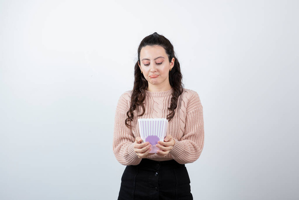 Jeune femme brune tenant un grand seau de popcorns. Photo de haute qualité - Photo, image