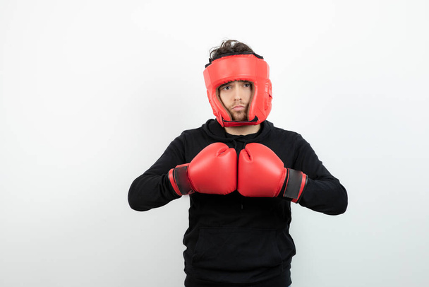 Retrato de un joven con sombrero de boxeo rojo de pie y posando. Foto de alta calidad - Foto, Imagen