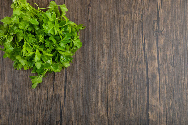 Folhas de salsa verdes saudáveis colocadas no fundo de madeira. Foto de alta qualidade - Foto, Imagem