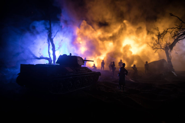 War Concept. Military silhouettes fighting scene on war fog sky background, World War Soldiers Silhouette Below Cloudy Skyline At night. Armored vehicle fight scene. Selective focus - Photo, Image