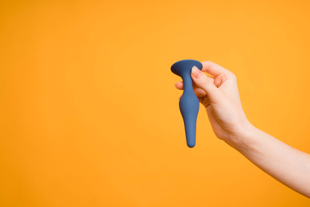 Adult sex toys, blue butt plug on an orange background - Фото, изображение
