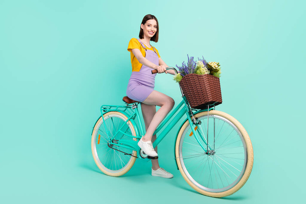 Full body photo of charming young happy woman ride bike smile summer isolated on pastel teal color background - Photo, image
