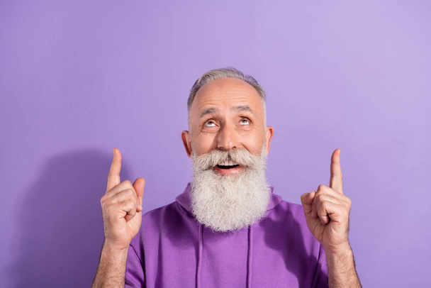 Portrait of trendy elderly retired pensioner grey-haired man showing up copy space offer ad isolated over purple violet color background - Фото, зображення