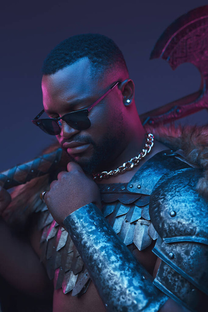 African warrior with sunglasses and axe against dark background - Foto, Imagem