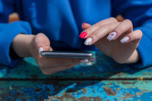 Dedos femeninos con enfoque selectivo. Smartphone en las manos, fondo abstracto con espacio de copia para texto. - Foto, imagen