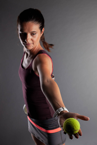 Professional female tennis player. Girl swinging racket preparing to serve - Foto, Bild