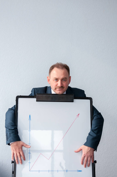 A man stands behind a white board with the schedule - Foto, Imagem