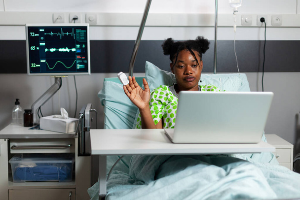 Afro-americana chica en hospital sala usando vídeo llamada - Foto, Imagen