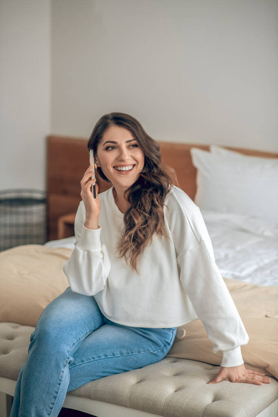 Young woman in white blouse and jeans with a smartphone - Foto, imagen
