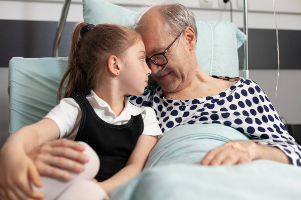 Cuidado nieta alegre tocando la frente con abuelo anciano enfermo - Foto, imagen