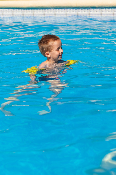 niño feliz nadando con flotadoresheureux garçon nage avec floaties - 写真・画像