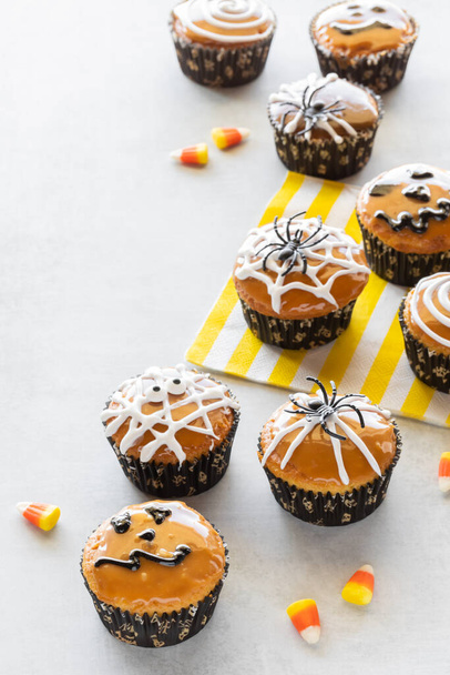Un assortimento di cupcake decorati di Halloween su uno sfondo leggero. - Foto, immagini