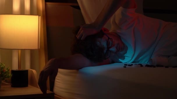Kaukasische man heeft slapeloosheid... een slapeloze nacht met zwarte pil voor emotionele stress... liggend op bed in een donkere kamer.. - Video