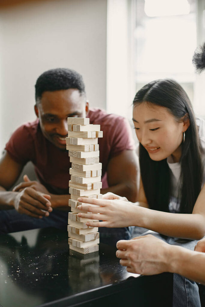 Three friends playing jenga in the living room - Photo, Image