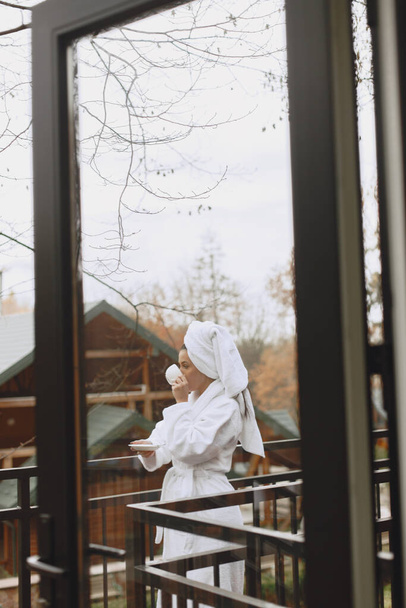 Picture of beautiful woman in white bathrobe - Фото, зображення