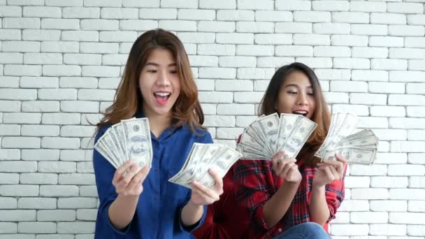 Happy young asian woman holding dollar money and throw in the air celebrate happiness dance wealth lottery money rain drop. Winner Success business woman throw cash flow Happy money smiling face - Footage, Video