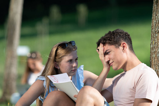Egy frusztrált diák közelsége, aki vizsgázik. A tinédzser próbálja felvidítani a sikertelen barátját. Egyetemi és akadémiai kudarc koncepció. - Fotó, kép