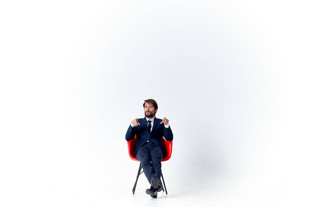бізнесмен у костюмі, сидячи на червоному стільці фінансового офісу менеджера
 - Фото, зображення