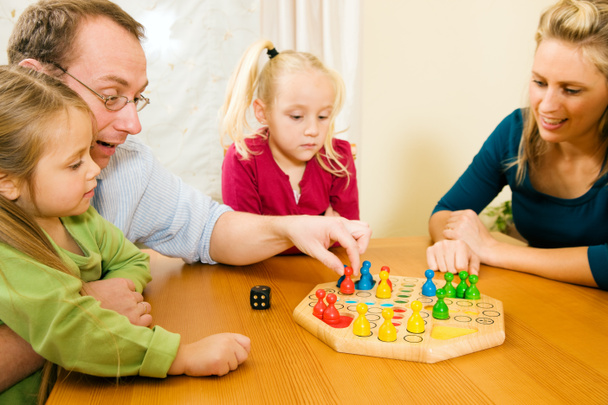 οικογένεια, παίζει ένα επιτραπέζιο παιχνίδι στο - Φωτογραφία, εικόνα